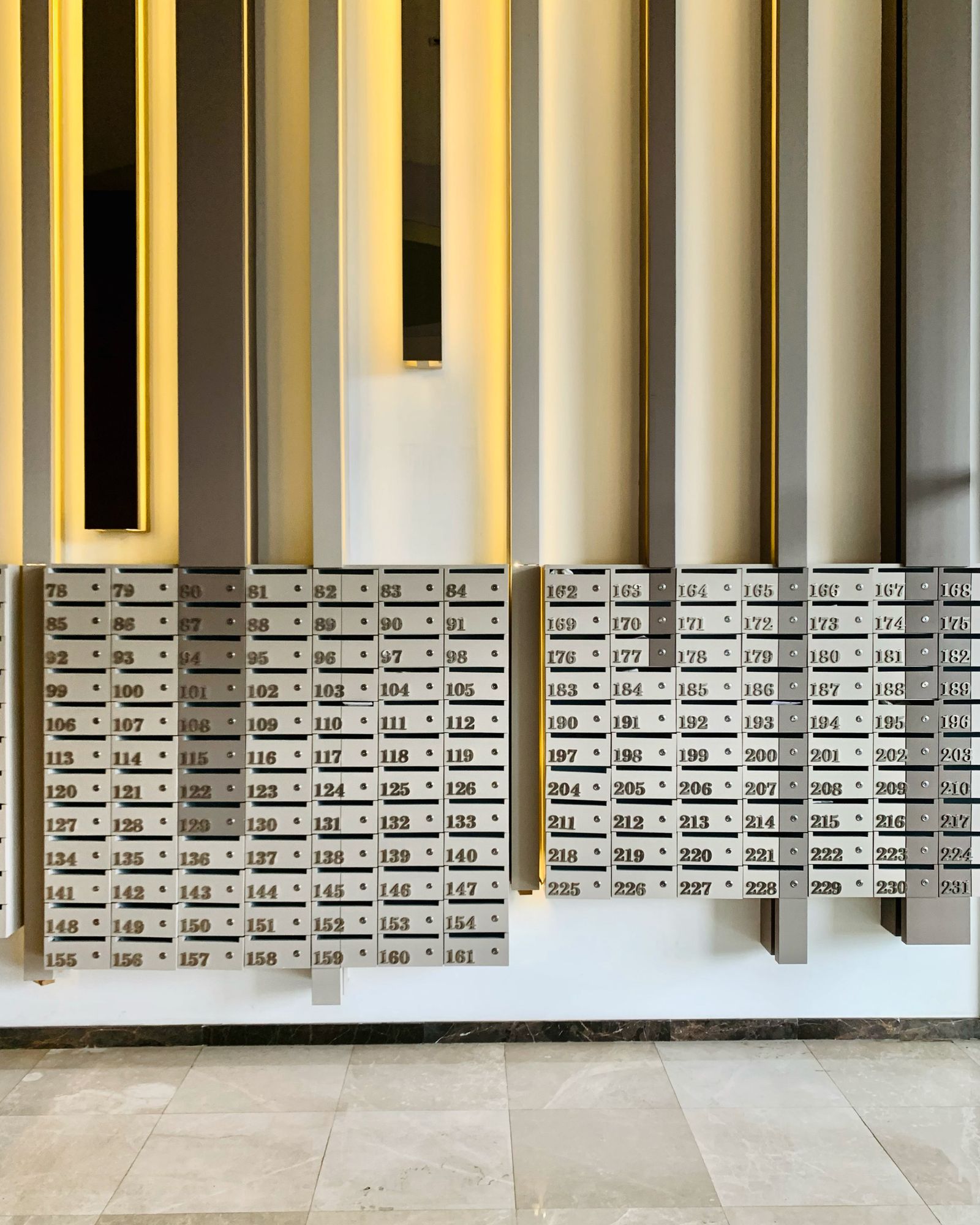 Wall of numbered mailboxes in a residential building lobby