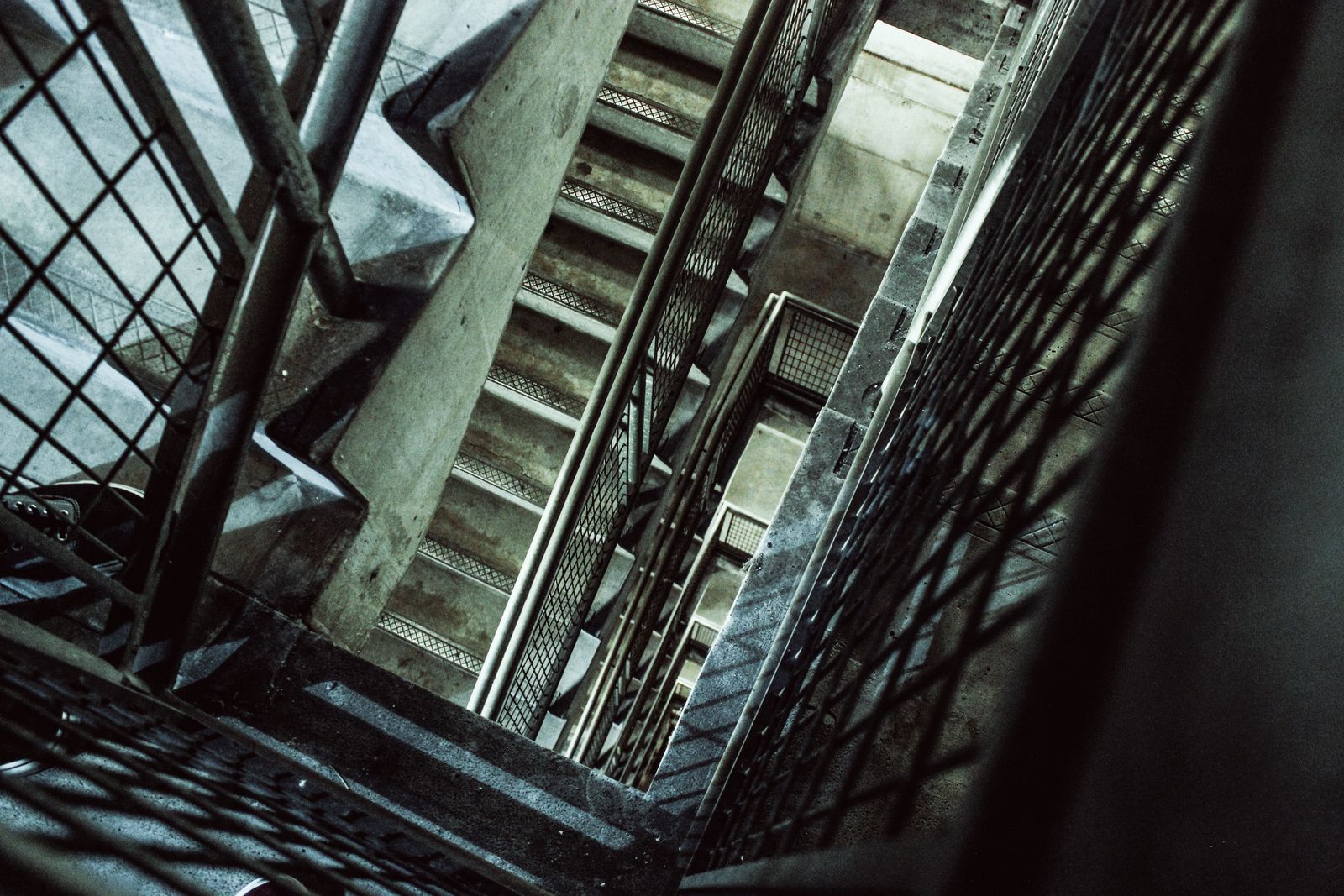 Concrete stairwell with metal railings, seen from above